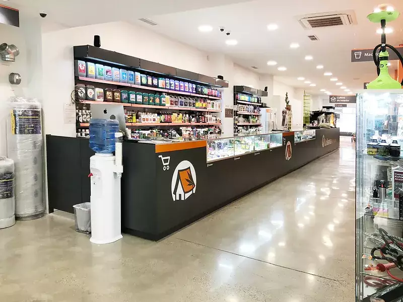 Mostrador del grow shop La Barraca de María en Valencia, con fertilizantes y accesorios de cultivo en estantería